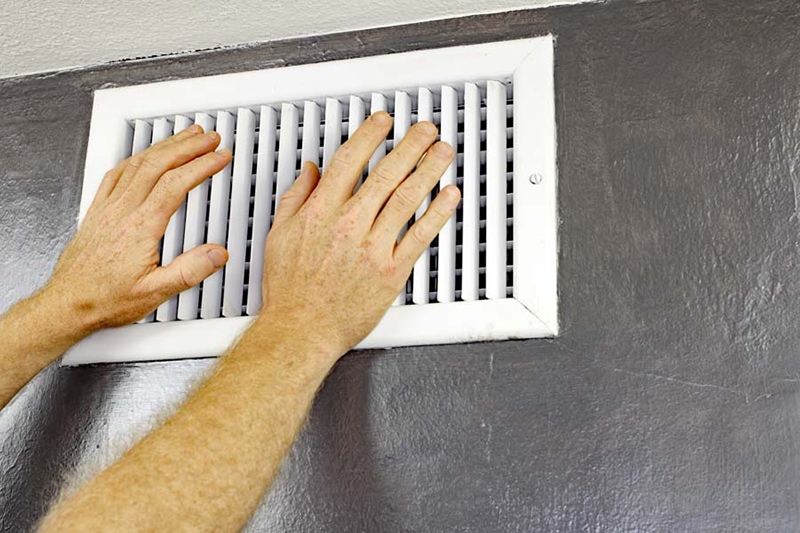 hands over white wall vent