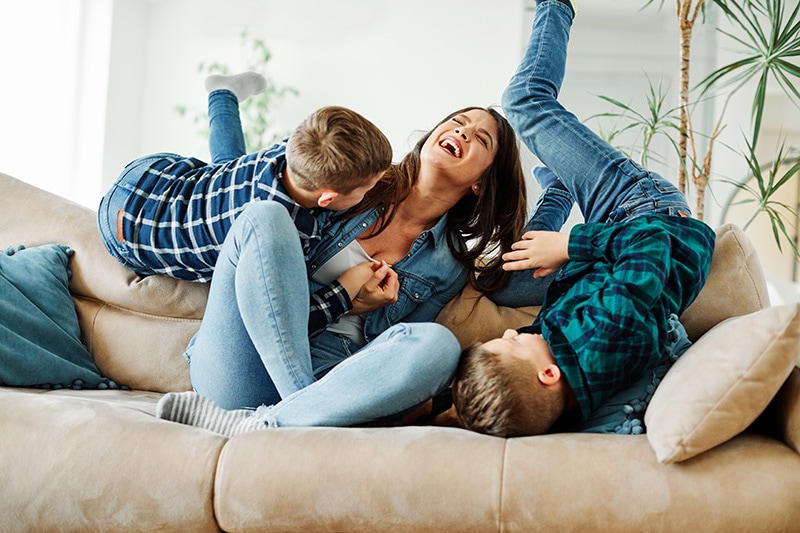 Mother and sons playing on a couch, The Basics of Winter Indoor Air Quality | Westford, MA | Basnett HVAC