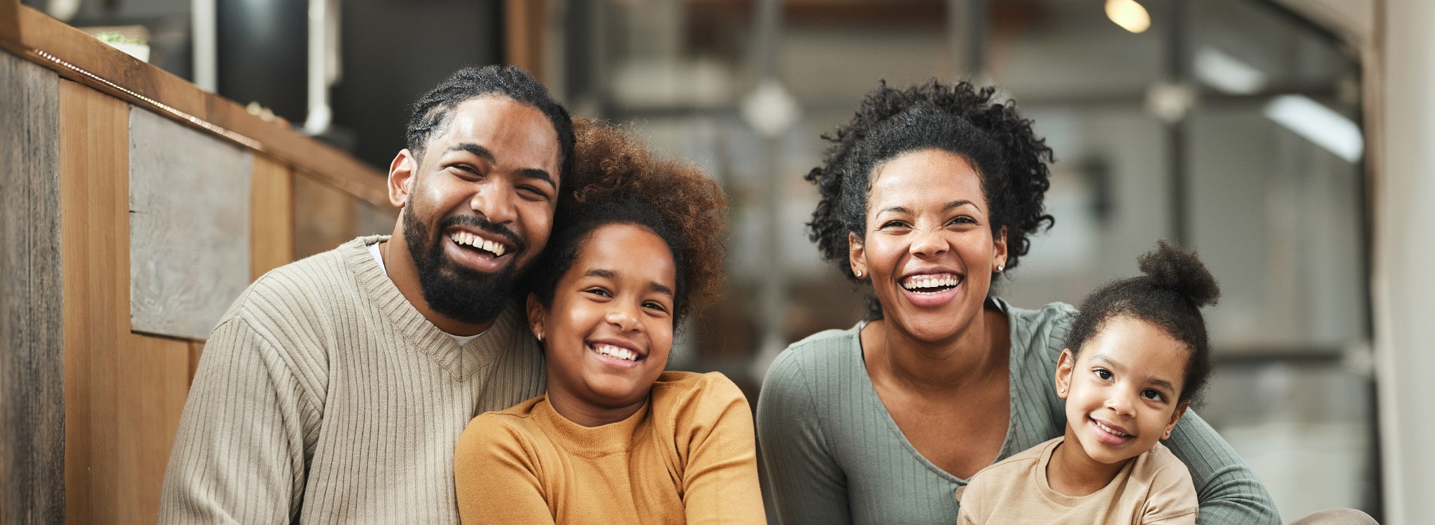 Happy family with two young children sitting on the floor.