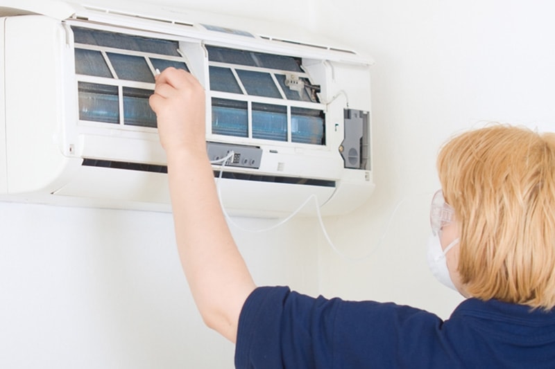 Woman switching out the filter in a ductless system