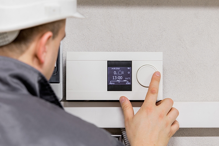 man adjusting thermostat