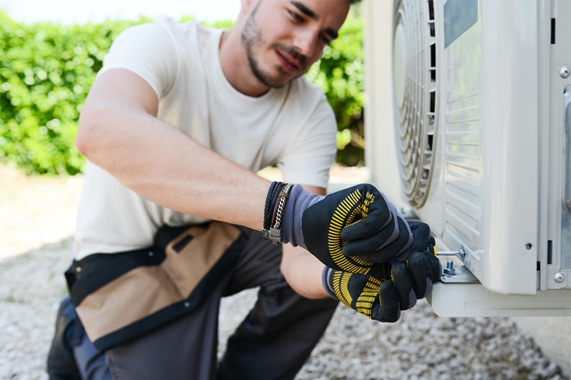 HVAC repairman fixing AC, Why is My Air Conditioner Leaking Water? | HVAC Maintenance, Repair