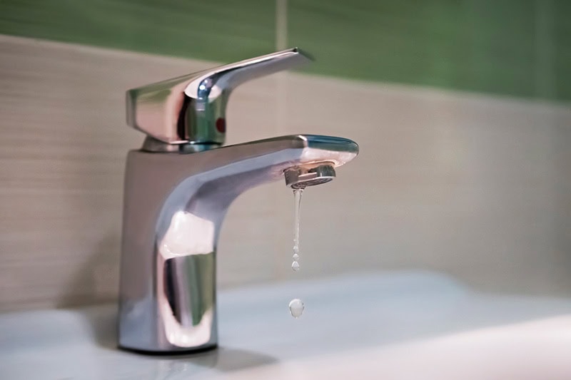 5 Plumbing Problems Costing You Money. Water dripping from a faucet.