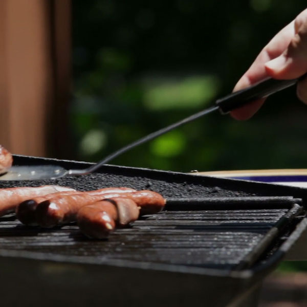 Cooking hotdogs outdoors in the summer to save money on AC indoors.