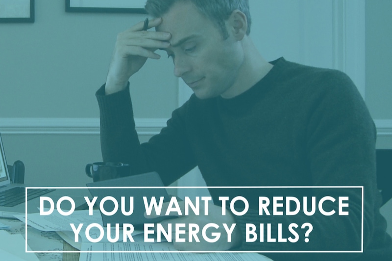 A middle aged man, looking stressed, sitting at a table going over his energy bills.