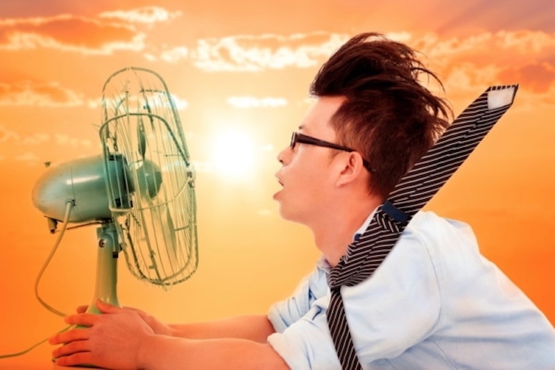 A man in glasses wearing a blue short sleeve button up shirt & striped holding a fan in front of his face with the wind blowing back his hair and tie, High Velocity AC System