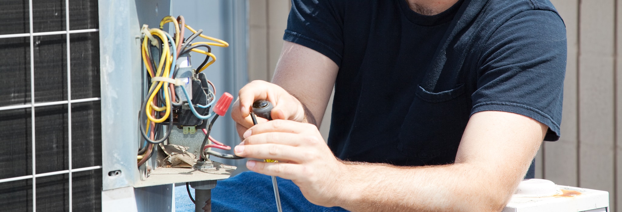 Young repairman fixing an industrial air conditioning compressor.