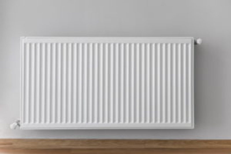 A radiator installed in a room with light gray walls and hard wood floors, Radiant Heating