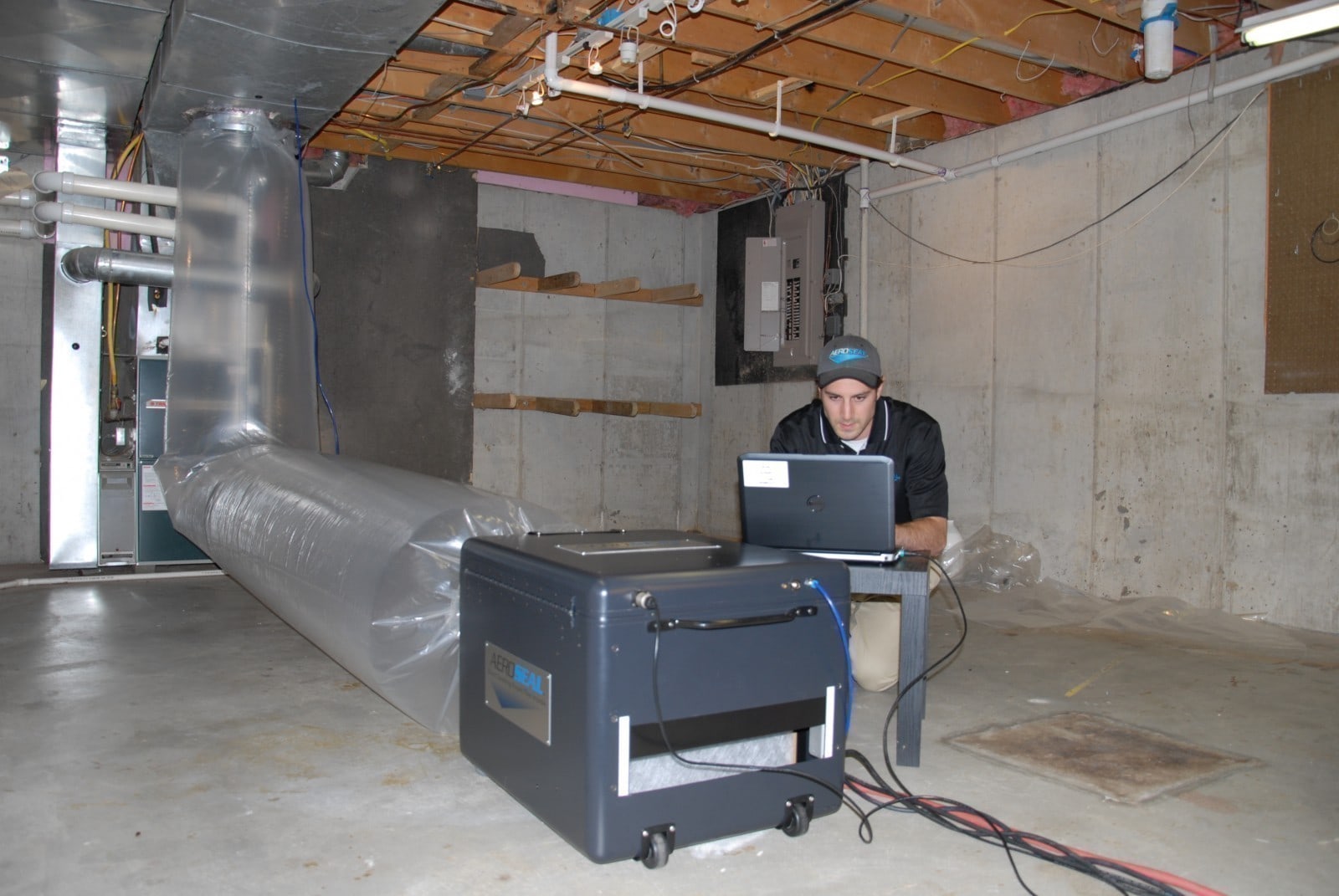 Technician sealing the air duct system with Aeroseal.